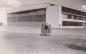 3 people in front of a large hangar