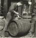 Cooper's yard foreman using a cooper's adze on a barrel