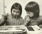 Two Inuit girls playing with a typewriter