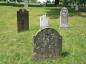 The grouped headstones of a family, whose last name is spelled differently on each marker.