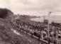 Bands and crowds march up towards the Tourist Bureau of Port Hastings village