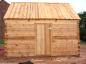 The front of the small log barn being built next to the Doucet House.