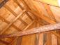 The roof of the small log barn is framed with logs.