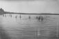 Main Beach; group of young men enjoying the water.