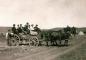 A group travelling by wagon pulled by horses.