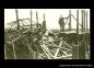 Men repairing damaged to a wood framed building.