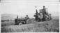 Archie Beatty (on tractor) and Ernie Geneau (on combine), combining wheat on George Ramseier's farm.