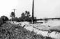 Flood of 1948. Sand bags running from the bottom right. Water and the C.P.R. bridge on the right.