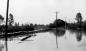 Flood of 1948. Image shows sand bags and 5 telephone poles running along water line.
