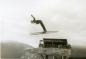 Ski jumper in mid-jump in front of the judges' tower