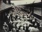 A crowd gathers on the platform at the station