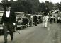 The marching band, complete with men on stilts,  nears the school