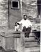 Tom Wong, the bunkhouse cook, at the east Bunkhouse entrance with the plant's mascot dog, Dobie,