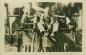 Parmer Dean, Harely Dean, and Jack Charmichael posing on the cow catcher (pilot) of a steam engine.