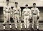 Four members of the Middleton cardinals stand in front of the dugout.