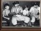 Two members of the Halifax Capitals sit and talk with two young baseball fans in the Capitals dugout