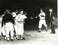 George Lewis of the Liverpool LArrupers is congratulated by teammates as he crosses home plate