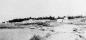 Looking northeast along the shore at Flour Cove showing old fish shacks and skids.