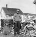 Donald Outhouse splits wood in his yard early in 1956. 