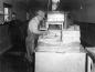 Theodore Teed, dipping fish in a preservative solution at Connor Brothers Ltd. Harry Crocker at left