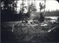 Dillon Wallace and guide George Elson sitting around fire after lunch.