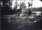 Dillon Wallace and guide George Elson sitting around fire after lunch.