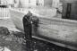 John Reid, uses a caulking iron and mallet to drive oakum between the planks of a fishing boat.