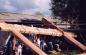 People raise the heavy housebeams of the tluu xaada naay longhouse.