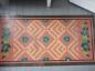 Old canvas mat with pattern similar to those used on hooked bedroom mats