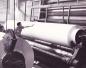 Worker examining paper roll, Bowaters Newfoundland Limited, 1960's.