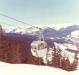 A man peaking out the window of the Creekside Gondola to get a better view of Coast Mountain Range. 