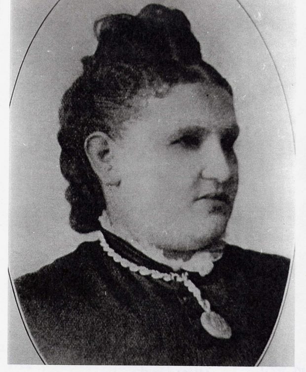 Formal black and white portrait of woman with lace collar and pendant