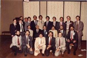 23 men in business suits arranged in three rows