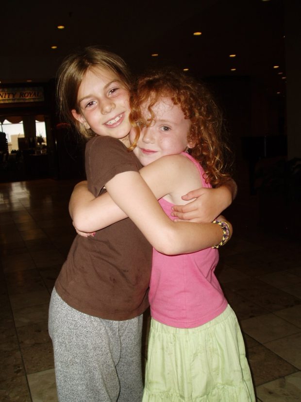 Two girls with arms wrapped around each other