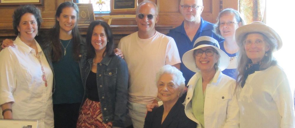 Seven women and two men gathered in front of display in Jewish Museum