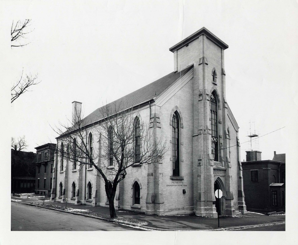 A brick building in the High Victorian Gothic style with arched windows and a central column once topped with a steeple.