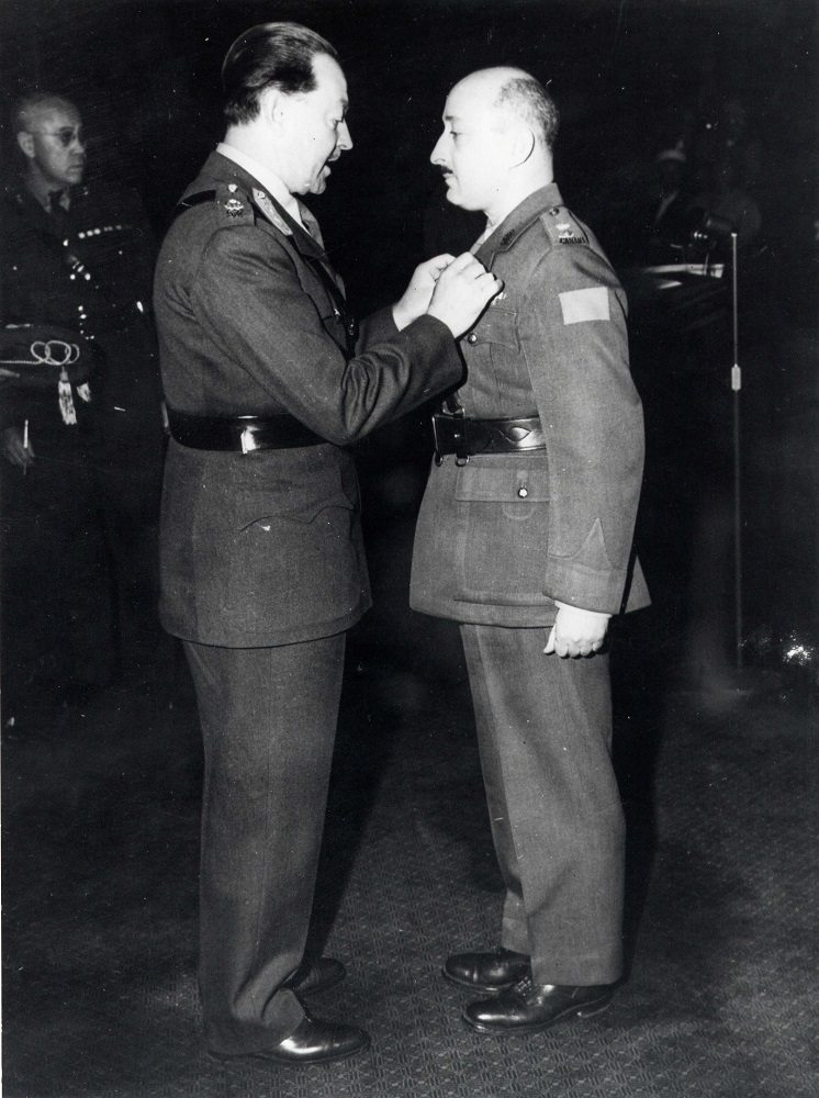 Two men in Canadian Army uniforms with the man at right receiving medal from man on left
