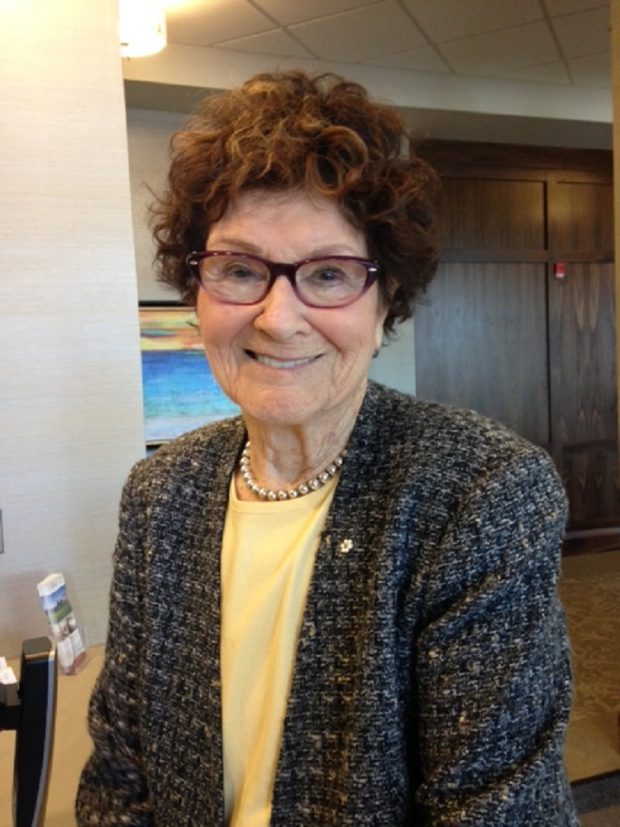 Formal portrait of woman with brown hair, glasses and tweed jacket