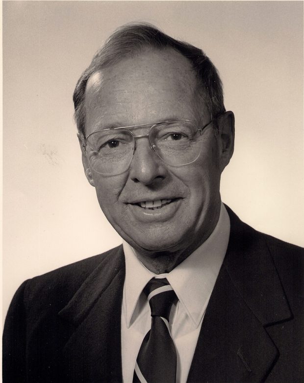 Formal portrait of middle aged man in business suit and glasses