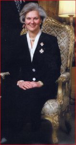 Formal portrait of women in jacket and long skirt and greying hair – seated in ornate arm chair