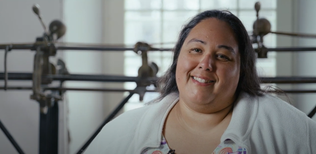Close-up of a person in front of a track sewing machine, in interview format.