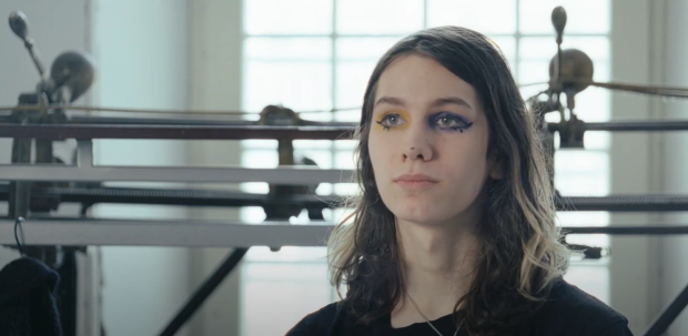 Close-up of a person sitting in front of a track sewing machine, in interview format.
