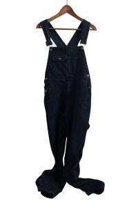 Black overalls on a wooden hanger.