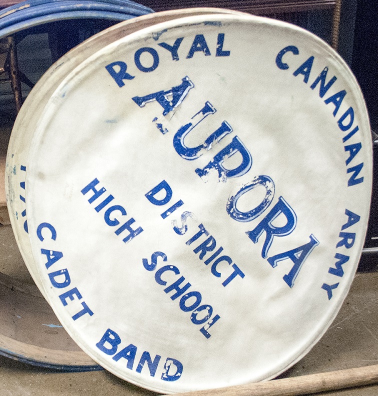 The skin of a drum dislodged from the drum body with painted blue lettering