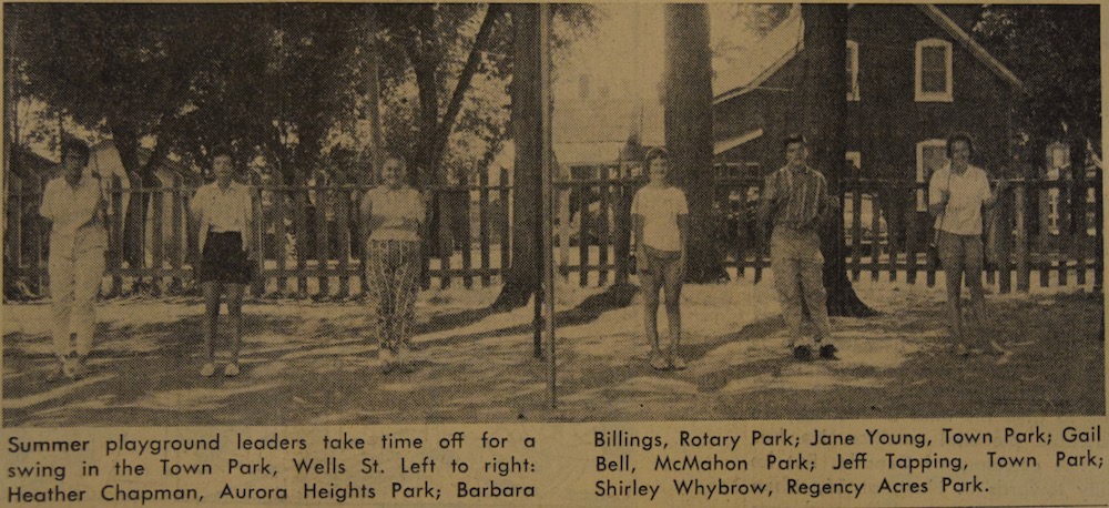 A sepia, black and grey image of six teenagers in a park. Each person is seated on a swing that is part of a playground swing set. They all have their legs extended down straight beneath them so they appear to be standing but are actually leaning back on the seat of the swing. In the background is a picket fence and behind it are house. There is a small caption in black text underneath the image.