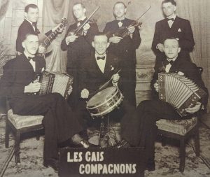 Black and white promotional photograph of the Gais Compagnons, taken in front of a false backdrop. The band members are all wearing suits and bow ties.