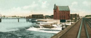 Colour tinted photograph of the train track bridge passing through Almonte looking towards the Town Hall