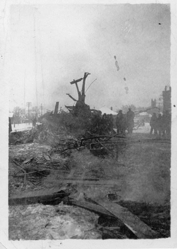 Black and white photograph of the debris from the Almonte Train Wreck with people standing behind it, 1942