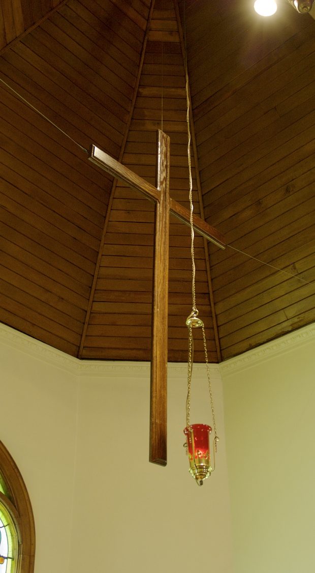 The cross is suspended above the altar. Made of oak and approximately 152 cm by 76 cm.
