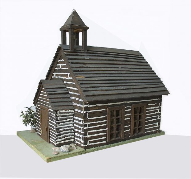 Model of log church on green base.